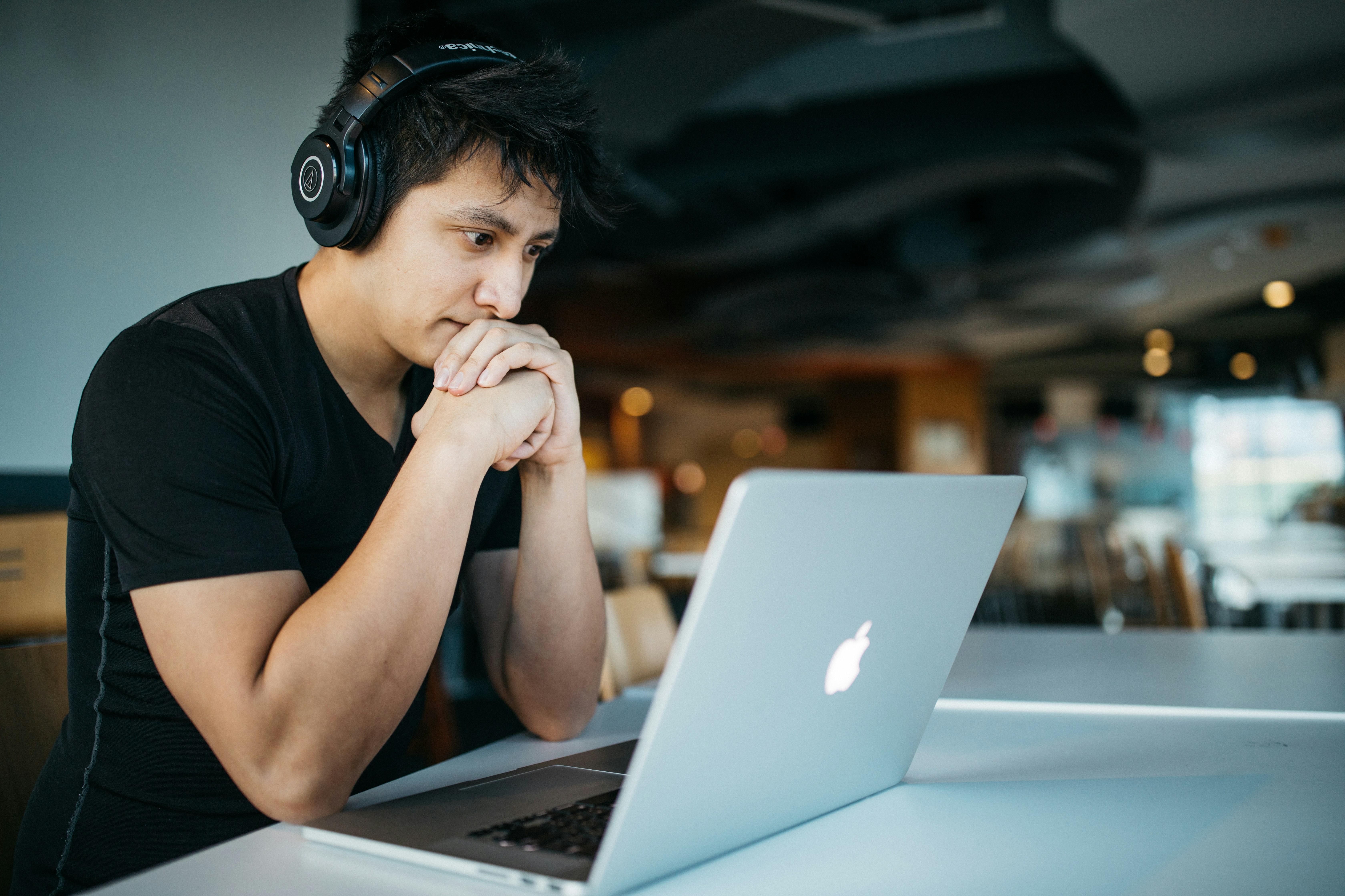 Young Latino Man with headphones and laptop wondering is counseling for me?