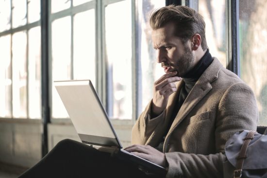 Bearded professional man with laptop searching fora a religious life coach